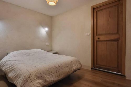 um quarto com uma cama e uma porta de madeira em Maison familiale pour 4 pers. em Ersa