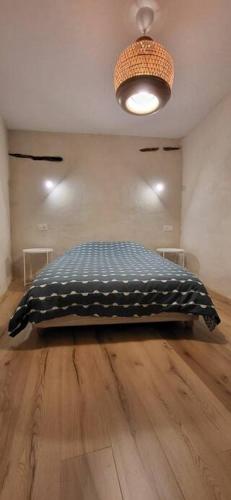 um quarto com uma cama num piso de madeira em Maison familiale pour 4 pers. em Ersa