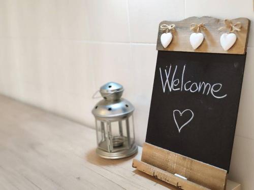 a welcome sign and a lantern on a table at Casa Vacanza - La Tartaruga in Milazzo