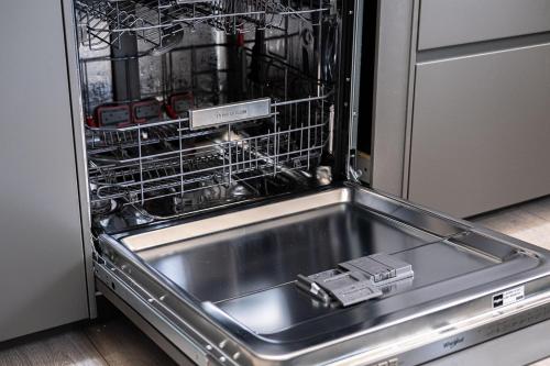 a dishwasher with racks of dishes in it at 7 Guests - 4 Bedroom - Free Wi-Fi - Kettering in Kettering