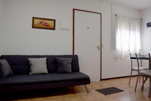 salon z niebieską kanapą i lustrem w obiekcie Silvia's house w mieście Ushuaia