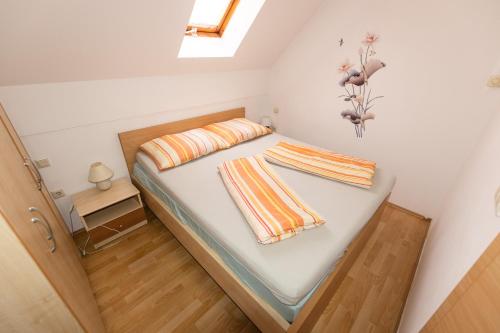 ein Schlafzimmer mit einem Bett mit zwei Kissen darauf in der Unterkunft Apartma Trobentica 15 in 3 Moravske Toplice in Moravske-Toplice