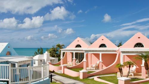 a pink house with the ocean in the background at Willowbank Resort in Somerset