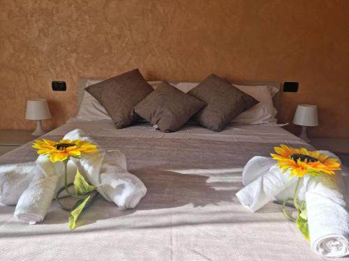 ein Bett mit Handtüchern und Blumen darüber in der Unterkunft Posto al sole in Lido di Ostia