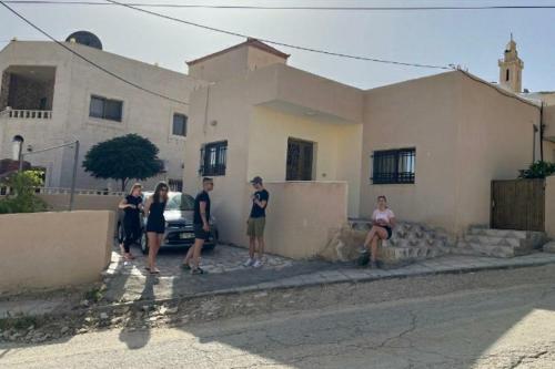 un grupo de personas parados frente a una casa en شقه فندقيه.Apartment,Petra, en Wadi Musa
