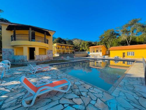 a resort with a swimming pool with a lounge chair at Hotel Boavista in Miguel Pereira