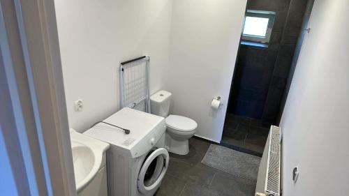 a white bathroom with a toilet and a sink at Apartament Mrągowo Mazury in Mrągowo