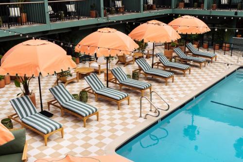 a row of chairs and umbrellas next to a pool at Palihotel Hollywood near Universal Studios in Los Angeles