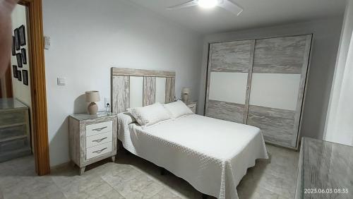 1 dormitorio blanco con 1 cama y vestidor en Chalet playa, en Benicarló