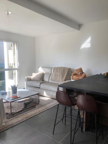un salon avec un canapé et une table dans l'établissement Appartement Aix en Provence vue Ste Victoire - BATIMENT B11 - 13090 AIX EN PROVENCE, à Aix-en-Provence