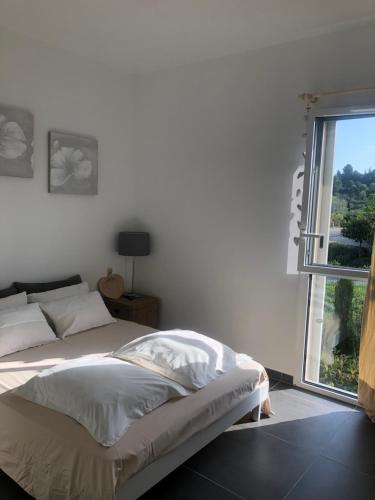 une chambre avec un lit et une grande fenêtre dans l'établissement Appartement Aix en Provence vue Ste Victoire - BATIMENT B11 - 13090 AIX EN PROVENCE, à Aix-en-Provence