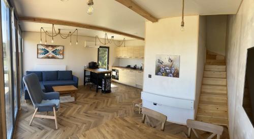 a living room with a blue couch and a kitchen at Polana Modraszek in Lasowka