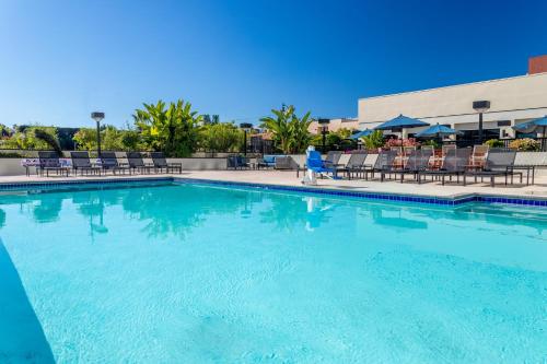 a large swimming pool with chairs and a building at Crowne Plaza Hotel Los Angeles Harbor by IHG in San Pedro