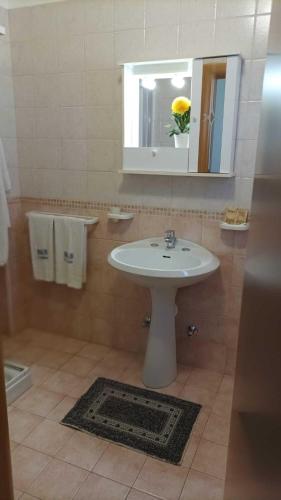 a bathroom with a white sink and a mirror at B&B Cristina in Torricella