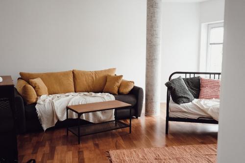 ein Wohnzimmer mit einem Sofa und einem Tisch in der Unterkunft Central Apartment Maister in Kranj