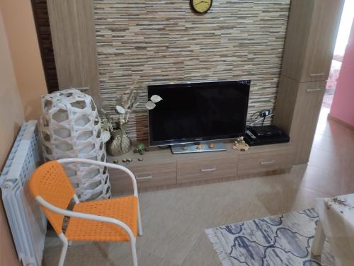 a living room with a tv and a chair at Casa lungo mare a Thesaloniki in Thessaloniki