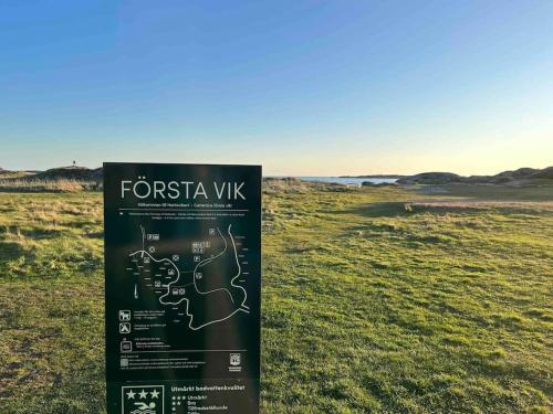 a sign in the middle of a field at Fräsch nybyggd stuga på Getterön Varberg in Varberg
