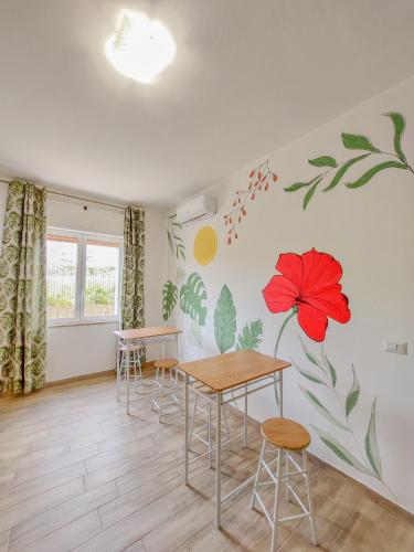 a dining room with a red flower mural on the wall at Metro Guest House in Naples