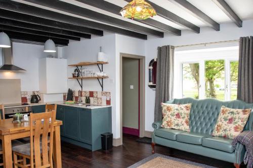 a kitchen and living room with a couch and a table at Stay Northside - Luxury Corporate & Leisure Stays Cottage, County Durham in Newton Aycliffe