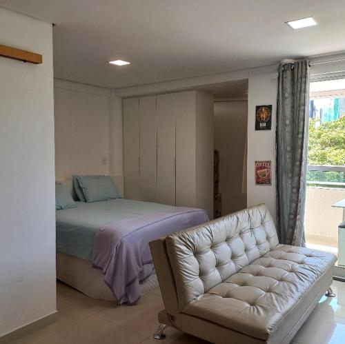 une chambre avec un lit, un canapé et une chaise dans l'établissement Flat na Praia do Bessa Atlântico Norte 303, à João Pessoa