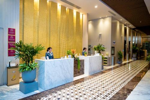 un hall avec deux personnes assises à un comptoir dans l'établissement Crowne Plaza Barranquilla, an IHG Hotel, à Barranquilla