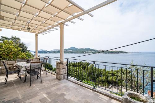 an outdoor patio with a table and chairs and the water at Villa Green Sunset in Dubrovnik