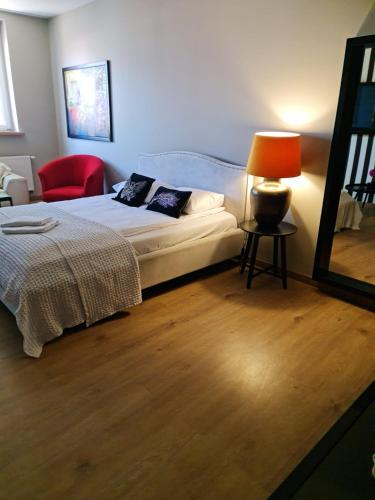 a bedroom with a bed and a lamp and a chair at Pod Beczką in Augustów