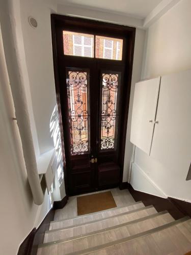 un couloir avec une porte et un escalier avec une porte dans l'établissement Studio Jeannette avec Balcon et juste à 130 metres Plage ! Plein Centre ! Wifi - Draps Serviettes inclus !, à Trouville-sur-Mer