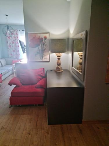 a living room with a red couch and a mirror at Pod Beczką in Augustów