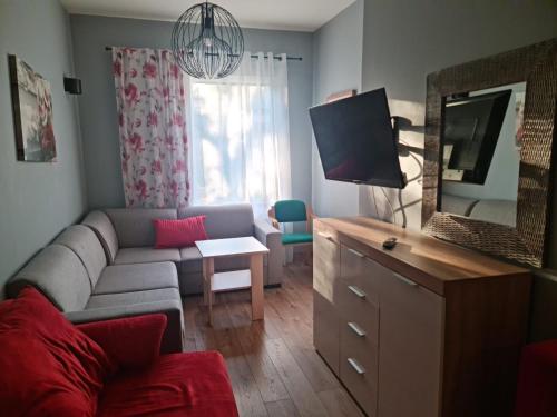 a living room with a couch and a tv at Pod Beczką in Augustów