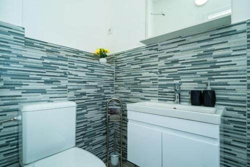 a bathroom with a white toilet and a sink at Villa Green Sunset in Dubrovnik