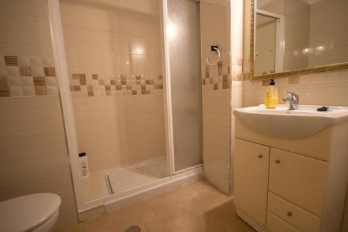 uma casa de banho com um chuveiro, um lavatório e um WC. em Apartamento La Traiña em Torre del Mar