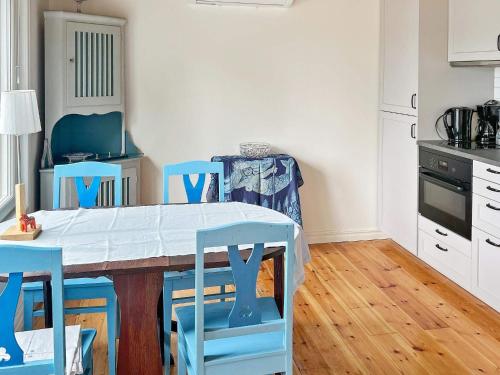 a kitchen with a table and blue chairs at 4 person holiday home in VÄRMDÖ-By Traum in Värmdö