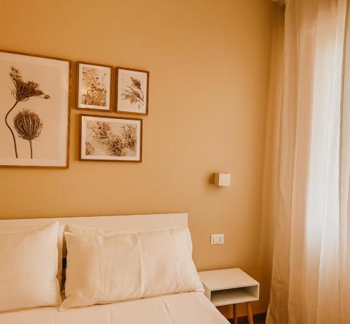 a bedroom with a bed and some pictures on the wall at Appartamento il Rosmarino in Portoferraio