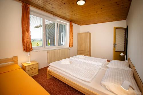 - une chambre avec 2 lits et une fenêtre dans l'établissement Chalupa Anežka, à Frymburk