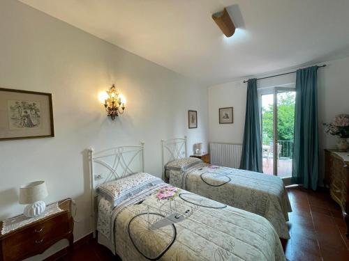 a bedroom with two beds and a chandelier at Villa Filippo in Cerliano