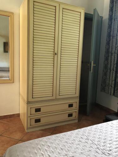 a large wooden cabinet in a bedroom with a bed at A Uardia in Tora