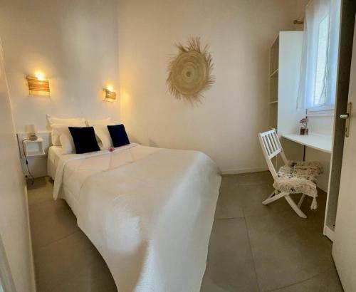 a bedroom with a large white bed and a chair at Résidence Colombara in Cargèse