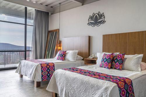 a hotel room with two beds and a large window at Hotel Boutique Marrakesh in Villa Corona