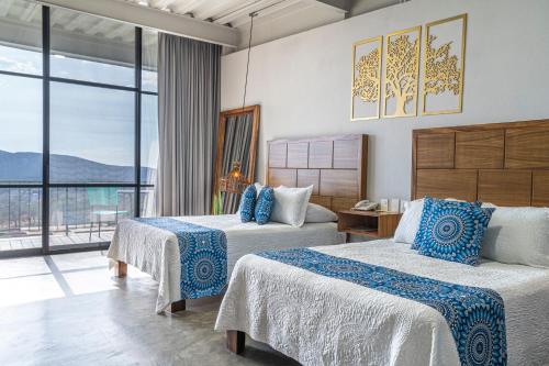 a hotel room with two beds and a large window at Hotel Boutique Marrakesh in Villa Corona