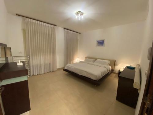 een slaapkamer met een groot bed in een kamer bij Lovely first floor tow bed rooms overviewing circular pool in Talabay Aqaba in Aqaba