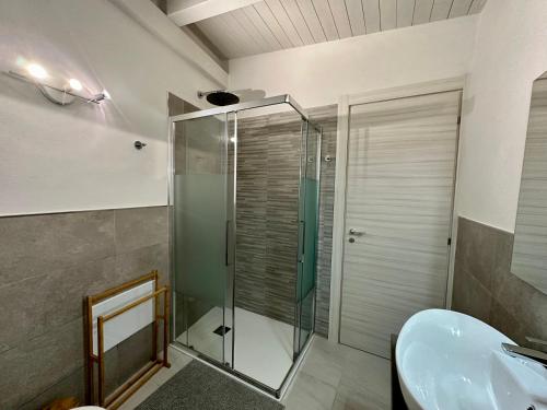 bagno con doccia in vetro e lavandino di Maison Céline a Siracusa