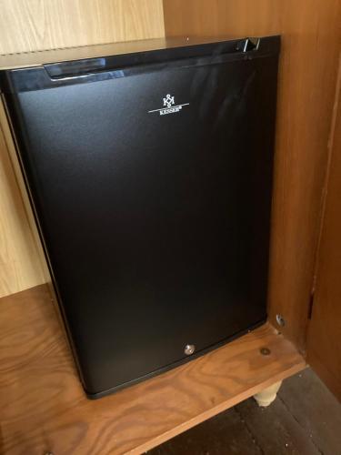 a black refrigerator sitting on top of a wooden shelf at Zur Baumwolle in Nürnberg
