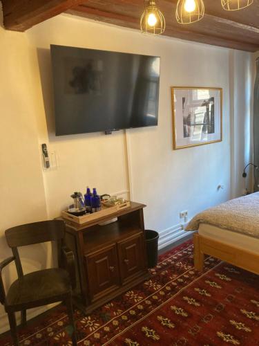 a bedroom with a bed and a desk with a television on the wall at Zur Baumwolle in Nürnberg