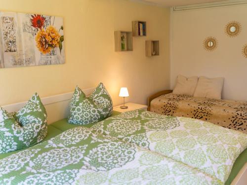 a bedroom with two beds with green and white pillows at Ferienwohnungen Christine Knoll in Bad Frankenhausen