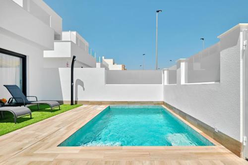 a swimming pool in the backyard of a house at Villa Blanco in San Pedro del Pinatar