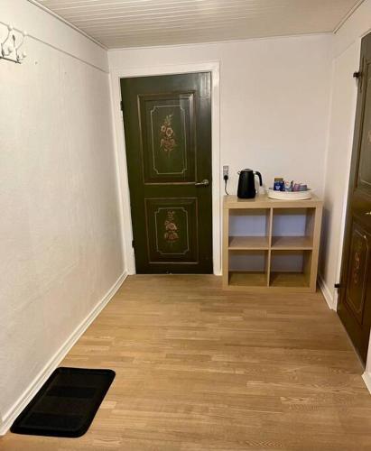a room with a green door and a wooden floor at beach room in Snogebæk