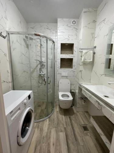 a bathroom with a shower and a toilet and a sink at Moonlight Apart-Hotel Batumi in Batumi