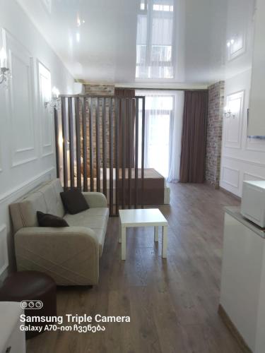 a living room with a couch and a table at Moonlight Apart-Hotel Batumi in Batumi