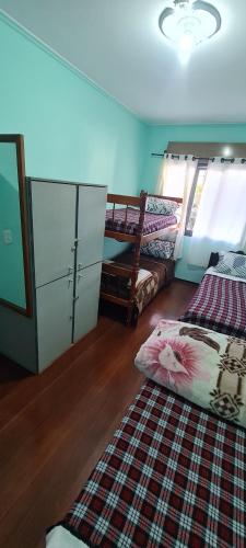 a bedroom with two twin beds and a rug at HOSTEL FAMILIA ZANATTA in Caxias do Sul